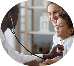 mother with son sitting on her lap while a doctor holds a stethoscope this his chest